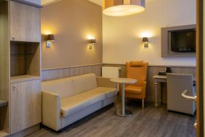 ein Wartezimmer mit Sofa und Tisch in der Unterkunft Blanckthys Hotel Voeren in Voeren