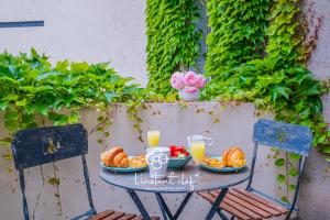a table with a breakfast of croissants and orange juice at Escale de charme à Tours - Parking, Patio & Hyper centre in Tours