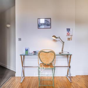 a desk with a chair and a lamp on it at Escale de charme à Tours - Parking, Patio & Hyper centre in Tours