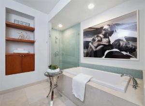 a bathroom with a large painting above a bath tub at Elegant Three-Bedroom Beachfront Home With Wide Ocean Views in Redondo Beach