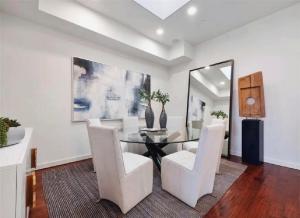 a dining room with a table and white chairs at Elegant Three-Bedroom Beachfront Home With Wide Ocean Views in Redondo Beach +21 photos