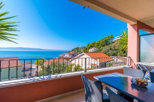 a balcony with a table and chairs and the ocean at Apartments Kunac in Podgora