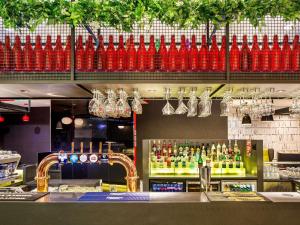 a bar with red vases hanging from the ceiling at ibis London Blackfriars in London