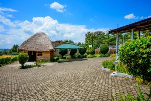 GahondoQuality Inn Motel, Nyanza的一座凉亭和一座茅草屋顶的建筑