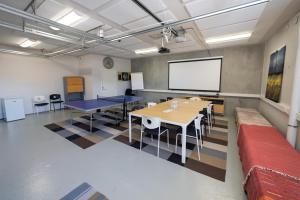 una sala riunioni con tavoli e schermo proiettore di Villa Merellä a Kalajoki