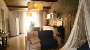 een woonkamer met een bank en een koelkast bij Loft Caeté in Araruama