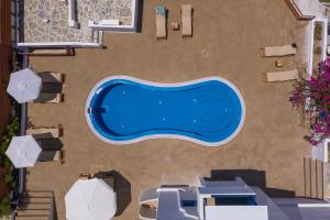 una vista dall'alto di una piscina con tavoli e ombrelloni di Apollon Rooms a Pollonia