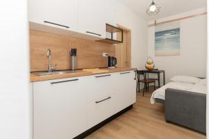 a kitchen with a sink and a living room at Apartamenty U Dragana in Kaštela +39 photos