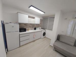 a kitchen with a white refrigerator and a sink at סויטת הזהב in Ashkelon