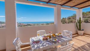 einen Tisch und Stühle auf dem Balkon eines Hauses in der Unterkunft Villa Diego Torrox by Ruralidays in Torrox