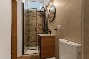 a bathroom with a shower and a toilet and a mirror at Apartamenty U Dragana in Kaštela