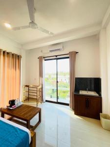 a bedroom with a bed and a table and a bathroom at Crossing Royal in Mirissa