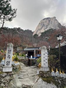 Ein Berg in der Ferne mit einem Tempel und Zeichen in der Unterkunft Blue Mansion Seoul in Seoul