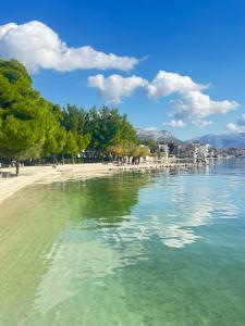 a view of a beach with trees and the water at Apartamenty U Dragana in Kaštela
