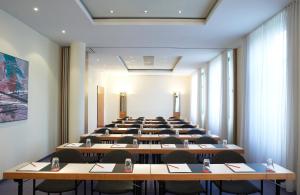 Großes Zimmer mit Tischen und Stühlen in der Unterkunft Hotel Magdeburg City Center by Leonardo Hotels in Magdeburg