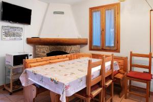 Chalet Bellavista في كييزا دي فالمالينكو: غرفة طعام مع طاولة ومدفأة