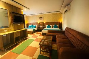 a hotel room with a couch and two beds at Sitara Economy The Pacific, Haridwar in Haridwār +22 photos