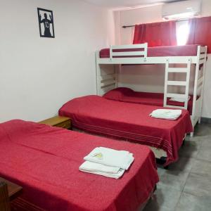 2 Etagenbetten in einem Zimmer mit roter Bettwäsche in der Unterkunft Apart Mi Kaú in Catriel