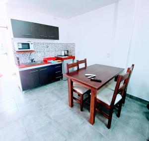 eine Küche mit einem Holztisch und Stühlen in einem Zimmer in der Unterkunft Apart Mi Kaú in Catriel