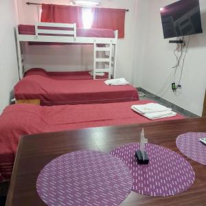 Zimmer mit 2 Etagenbetten und einem Tisch mit einem Tisch in der Unterkunft Apart Mi Kaú in Catriel