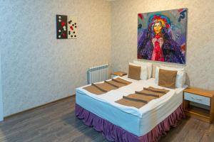 a bedroom with a bed with a painting on the wall at Salam Baku Hotel (SBH) in Baku