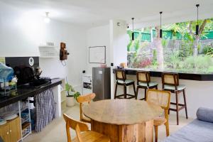 a kitchen with a table and chairs in a room at Beehive Cottages in Amed