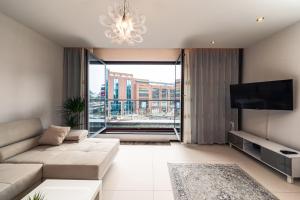a living room with a couch and a flat screen tv at Apartament Avignon in Wrocław