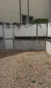 a building with a fence with doors on it at Escale de charme à Tours - Parking, Patio & Hyper centre in Tours