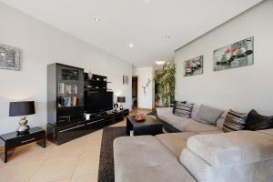 ein Wohnzimmer mit Sofa und Fernseher in der Unterkunft Casa Cemaya in Santo Amaro