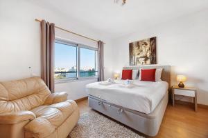 ein Schlafzimmer mit einem Bett und einer Couch und einem Fenster in der Unterkunft Casa Cemaya in Santo Amaro + 20 Fotos