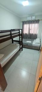 una stanza con due letti a castello e una finestra di Apartamento 2 quartos c/ ar-condicionado e garagem a Indaiatuba