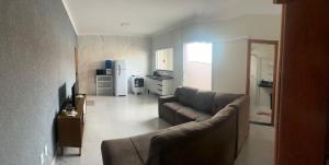 un soggiorno con divano e cucina di Apartamento 2 quartos c/ ar-condicionado e garagem a Indaiatuba