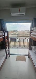 una camera con due letti a castello e una grande finestra di Apartamento 2 quartos c/ ar-condicionado e garagem a Indaiatuba Altre 32 foto