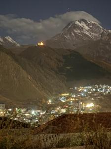 a view of a city and a mountain at night at ADRESATI Stepantsminda in Stepantsminda