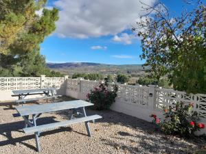 a picnic table on a patio with a white fence at DJM Palms - Shared Casa Rural - Casa Rural Compartida - No es una casa privada in Ayora
