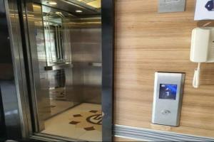 a phone on a wall next to a glass door at Senayan Suites in Jakarta