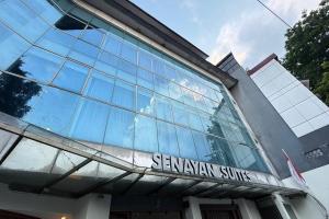雅加达Senayan Suites的一座玻璃建筑，上面挂着一块牌子，写着“senwegian service”（森威吉安服务）。