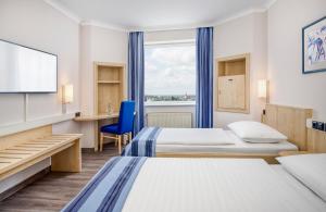 Giường trong phòng chung tại Hotel Freiburg City Center by Leonardo Hotels +17 ảnh