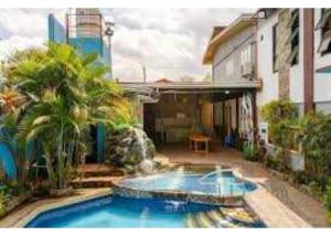 a swimming pool in front of a building at OYO 1187 Rose And Ross Place Budget Hotel And Private Resort in Kabaong