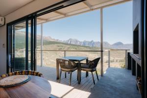 ein Glashaus mit einem Tisch und Stühlen auf dem Balkon in der Unterkunft untether on Olive View in Wellington