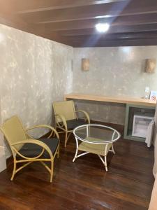 Zimmer mit 3 Stühlen, einem Tisch und einer Theke in der Unterkunft Hotel Pé na Areia in Penha