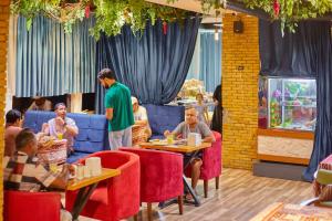 a group of people sitting at tables in a restaurant at Salam Baku Hotel (SBH) in Baku