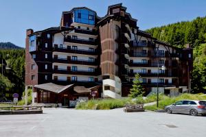 een groot gebouw met een auto ervoor geparkeerd bij Résidence Saboia B54 Clés Blanches Courchevel in La Tania