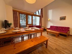 een woonkamer met een tafel en een rode bank bij Résidence Saboia B54 Clés Blanches Courchevel in La Tania