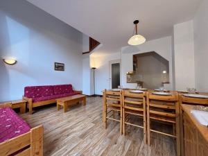 een woonkamer met een bank, een tafel en stoelen bij Résidence Saboia B54 Clés Blanches Courchevel in La Tania
