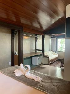ein Zimmer mit einem Bett mit einem Schwan darauf in der Unterkunft Hotel Pé na Areia in Penha