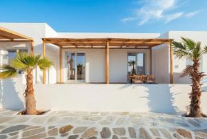 two palm trees in front of a house at Kyma Paros Apartments 1 