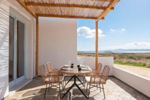 a table and chairs on the balcony of a house at Kyma Paros Apartments 1  +9 photos