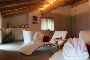 a living room with white chairs and a table at Twinssuites - Adults friendly in Limone sul Garda