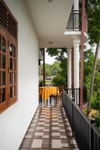 un tavolo da pranzo su una veranda con balcone di JAMI River Side Hotel & Yala Safari Place a Tissamaharama